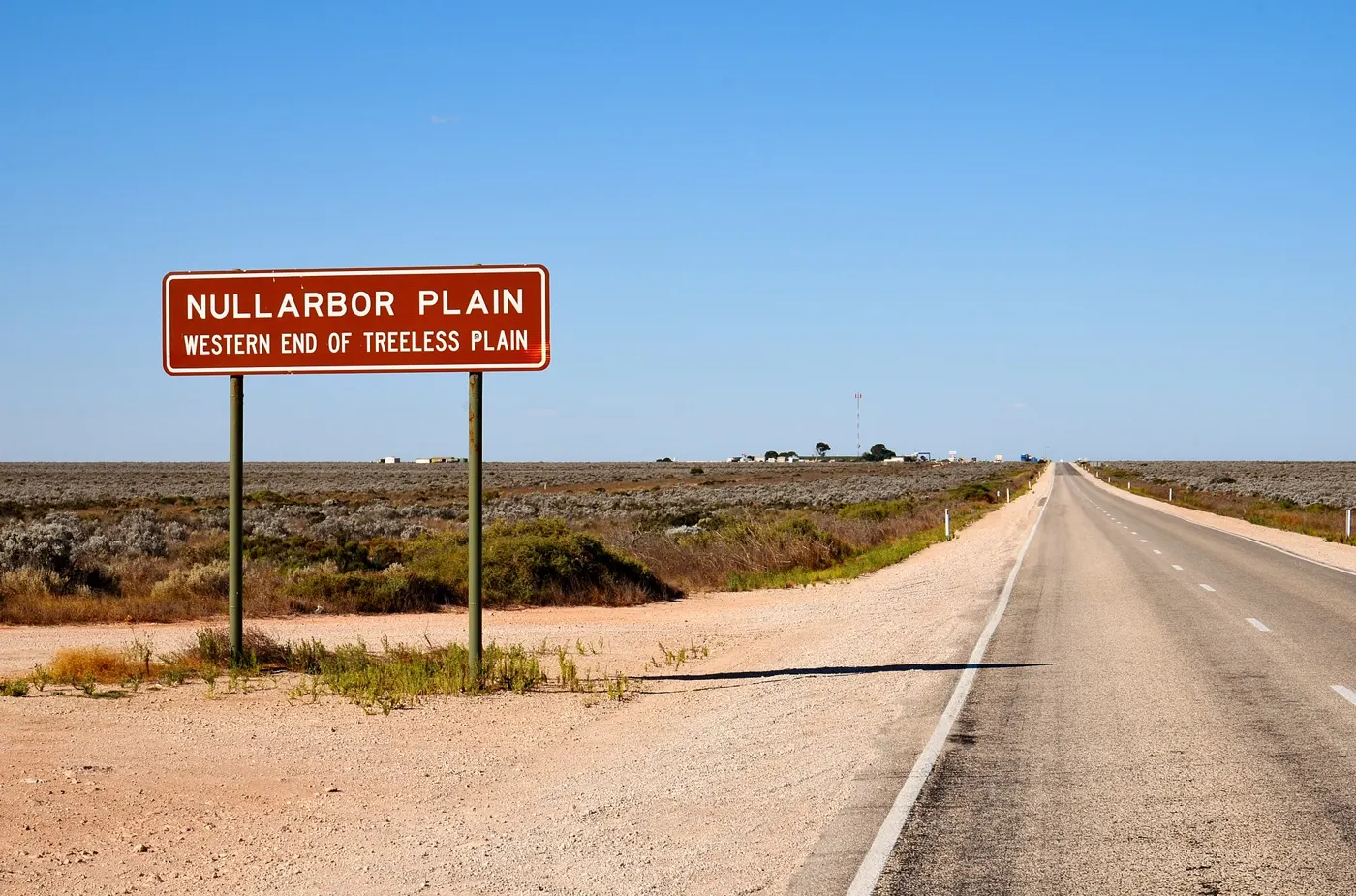 A Nullarbor Plain highway sign beside a long straight outback road